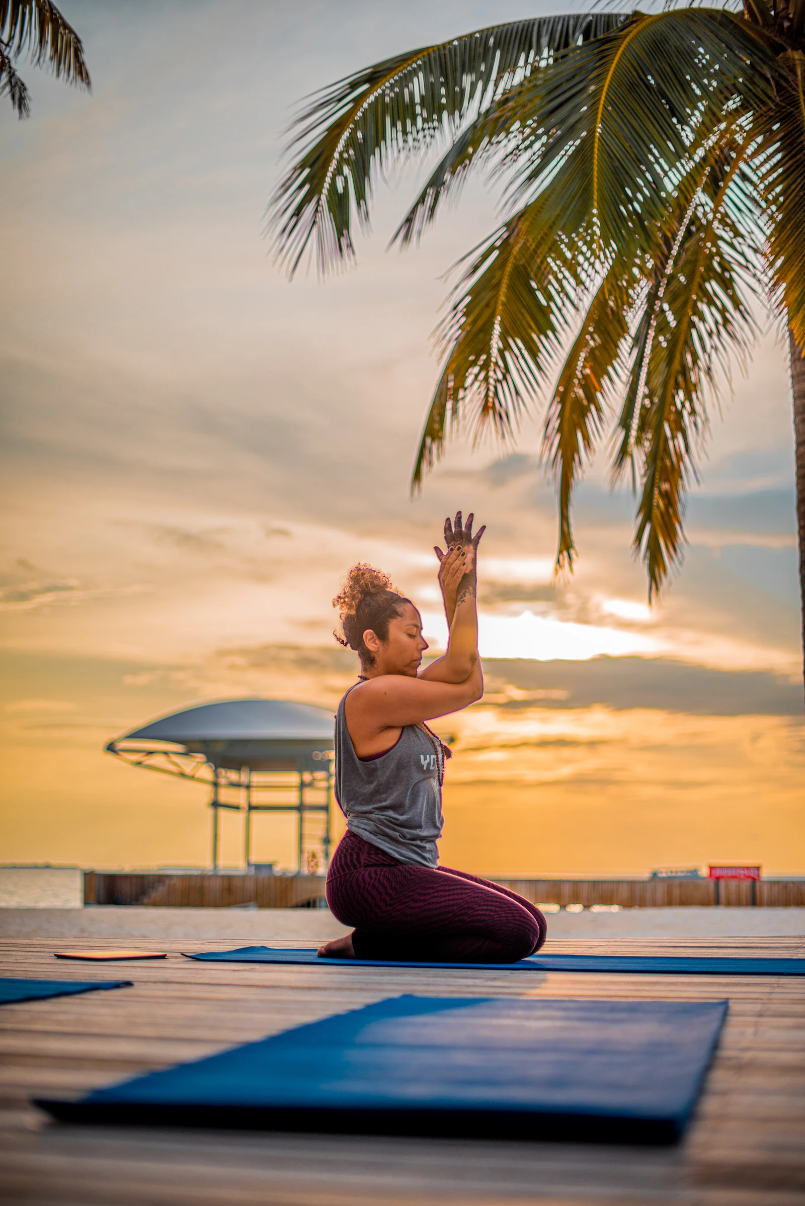 Woman sitting peacefully on a yoga mat in calm morning light