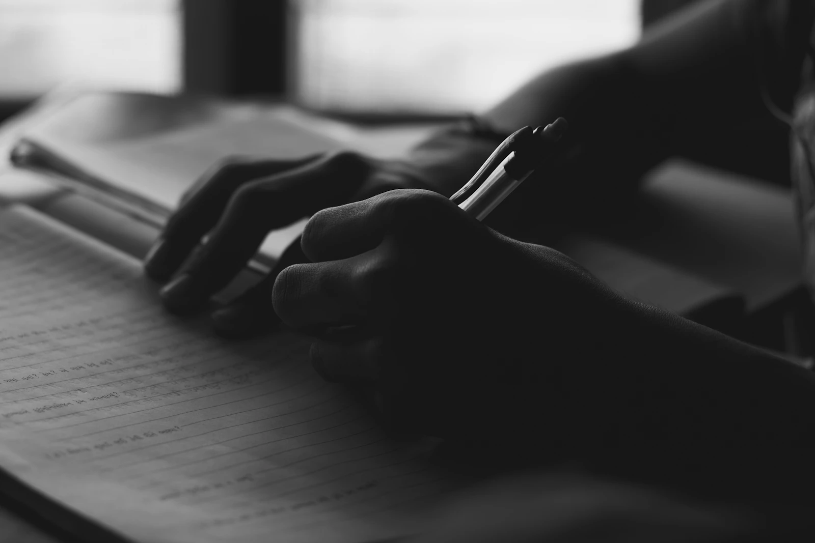 A person writing in a notebook with a pen — identity rehearsal