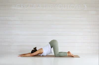 A practitioner in child's pose on a yoga mat